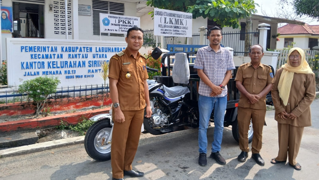 Wendi Humas PT Siringoringo memakai kemeja saat memberikan bantuan ke Kantor Kelurahan Siringoringo (portalswara.com/Zulkifli)