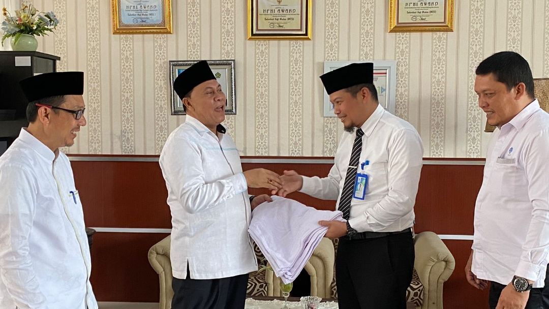 Plh Dirut Perumda Tirtanadi Ewin Putra saat menyerahkan handuk secara simbolis kepada Ka Kanwil Kemenagsu H Ahmad Qosbi (portalswara.com /dok)